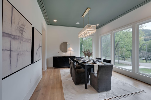 dining area featuring an inviting chandelier, light hardwood / wood-style flooring, and ornamental molding