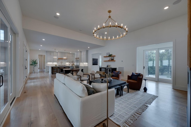 living room with a chandelier and light wood-type flooring