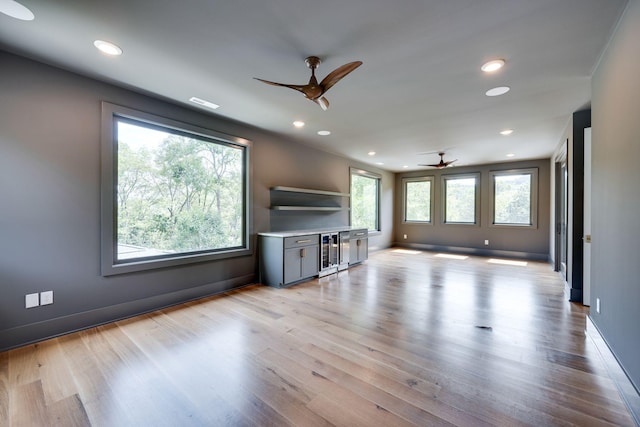 unfurnished living room with light wood-type flooring and ceiling fan