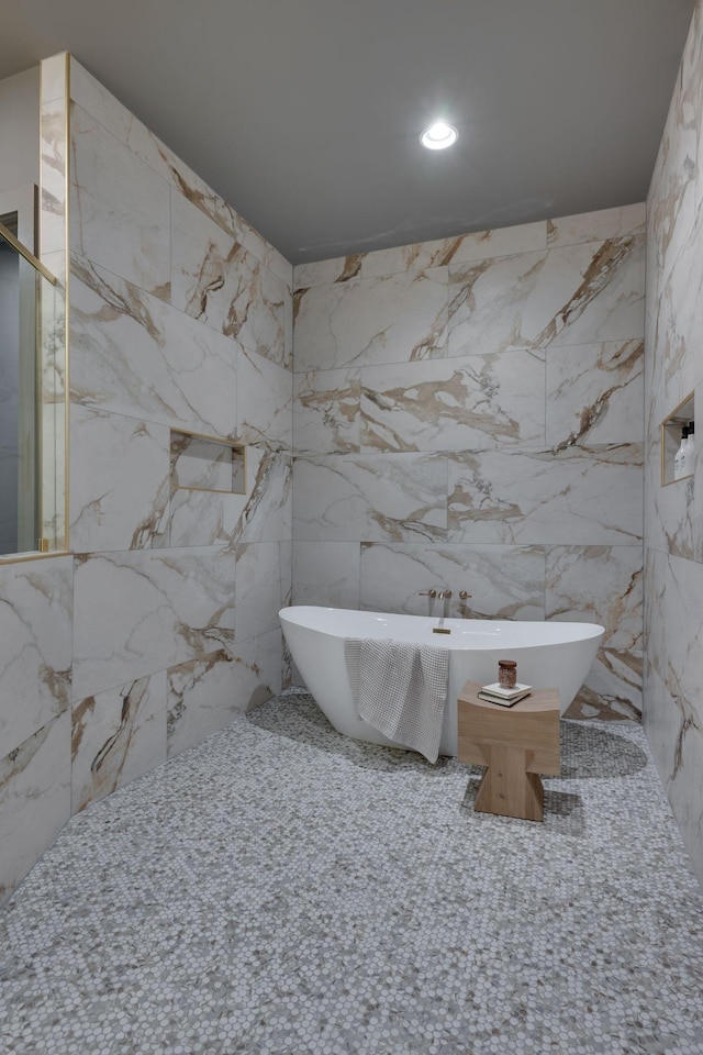 bathroom featuring a bathing tub and tile walls