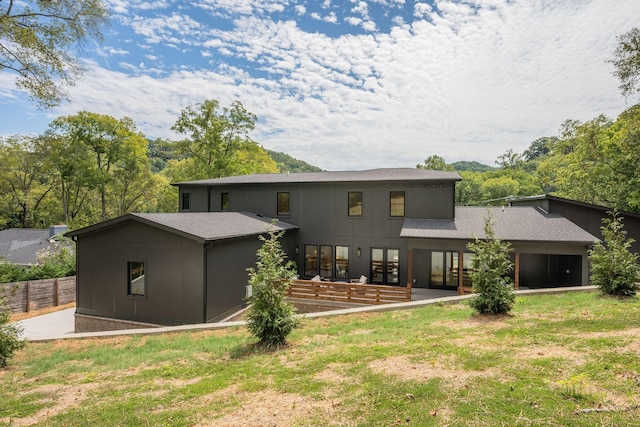 rear view of property featuring a lawn and a patio