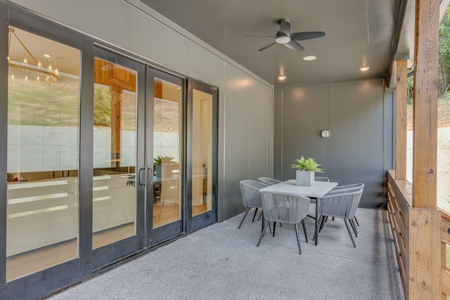 sunroom featuring ceiling fan with notable chandelier and french doors