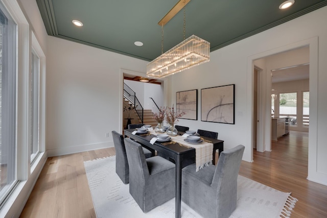 dining space featuring a chandelier, crown molding, and light hardwood / wood-style flooring