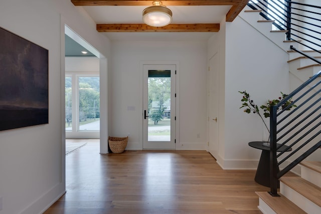 foyer entrance with beam ceiling and light wood-type flooring