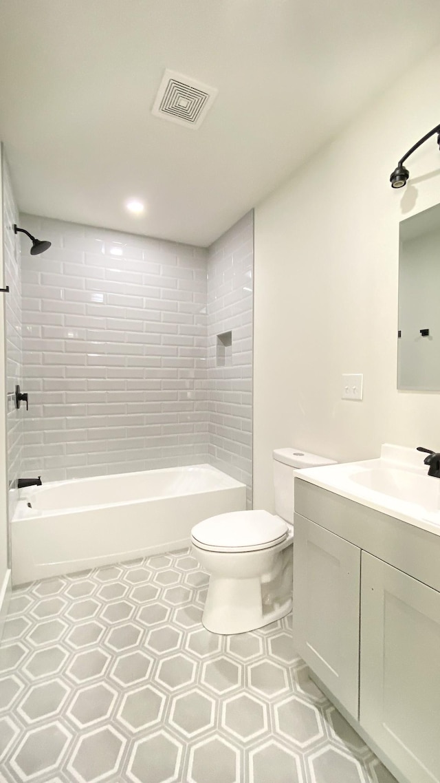 full bathroom featuring tile patterned flooring, vanity, toilet, and tiled shower / bath combo