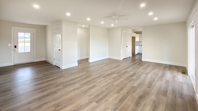 unfurnished living room with ceiling fan and light hardwood / wood-style flooring