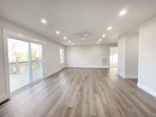 empty room with ceiling fan and light hardwood / wood-style floors