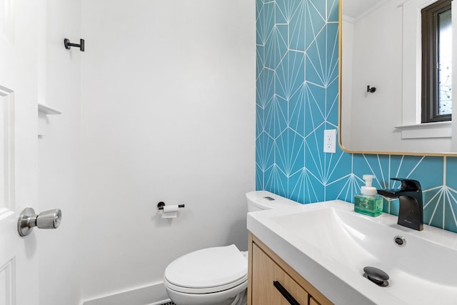 bathroom featuring tasteful backsplash, vanity, ornamental molding, and toilet