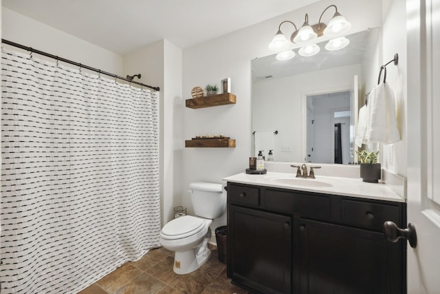 bathroom with vanity, curtained shower, toilet, and a chandelier