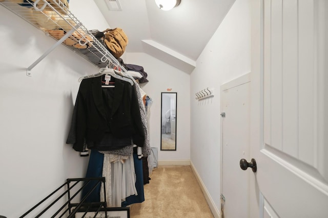 spacious closet featuring light colored carpet and vaulted ceiling