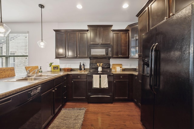 kitchen with black appliances, dark hardwood / wood-style floors, dark brown cabinetry, and hanging light fixtures