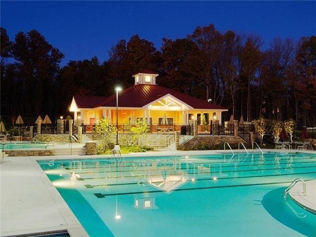 pool at twilight featuring a patio area