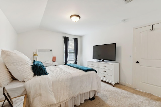 bedroom with light carpet and lofted ceiling