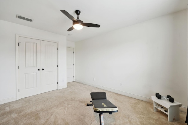 workout area featuring light carpet and ceiling fan