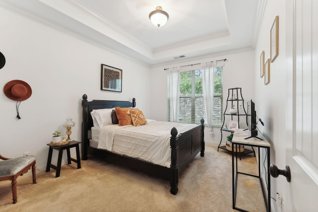 carpeted bedroom with a tray ceiling and ornamental molding