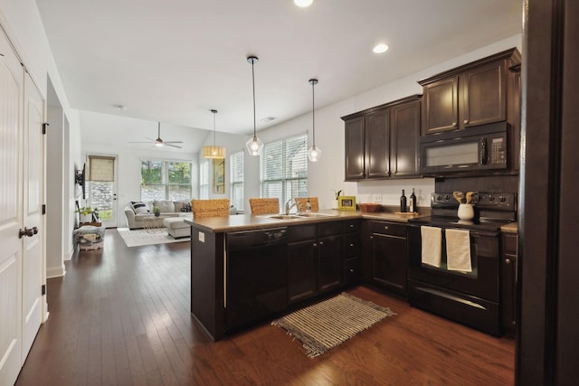 kitchen with kitchen peninsula, sink, hanging light fixtures, and black appliances