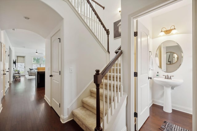 stairs with ceiling fan, hardwood / wood-style floors, and lofted ceiling