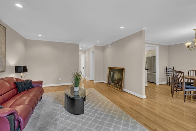 living room featuring hardwood / wood-style floors, an inviting chandelier, and crown molding