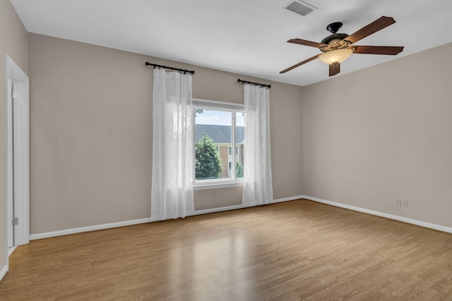 empty room with ceiling fan and light hardwood / wood-style floors