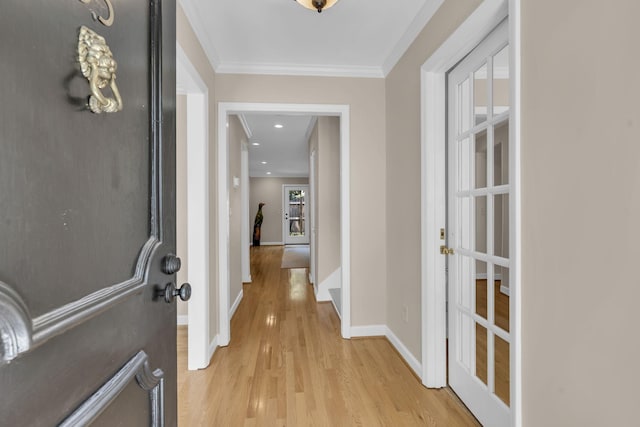 hall with light hardwood / wood-style flooring and ornamental molding