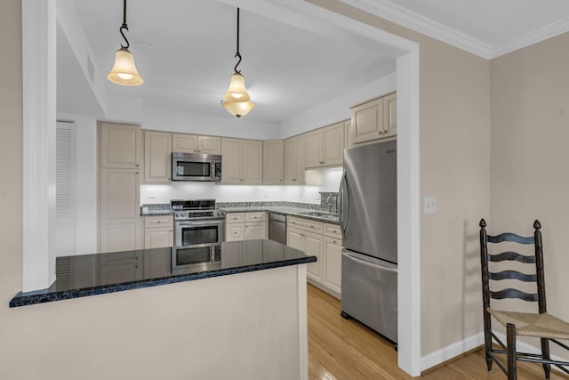 kitchen with sink, kitchen peninsula, pendant lighting, appliances with stainless steel finishes, and light wood-type flooring