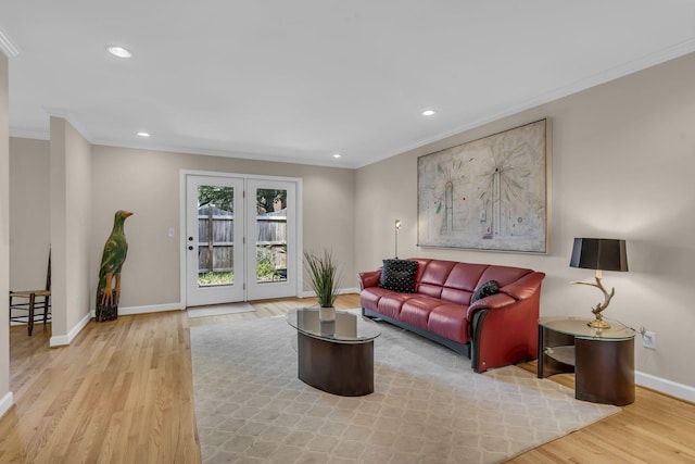 living room with light hardwood / wood-style flooring, baseboard heating, and crown molding