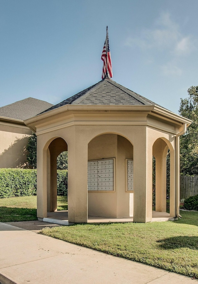 view of community with a lawn and a mail area