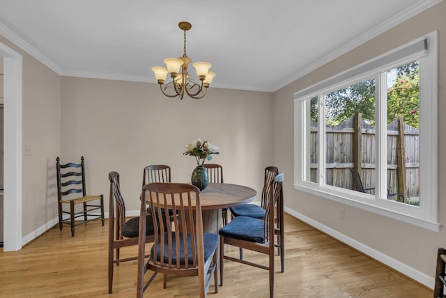 dining room with light hardwood / wood-style flooring, ornamental molding, and a notable chandelier