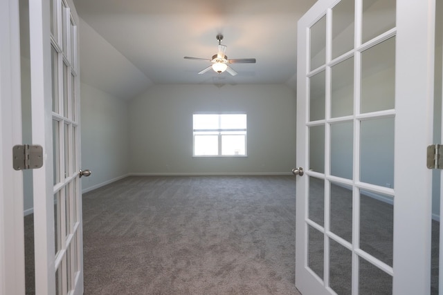 carpeted spare room featuring vaulted ceiling, french doors, and ceiling fan