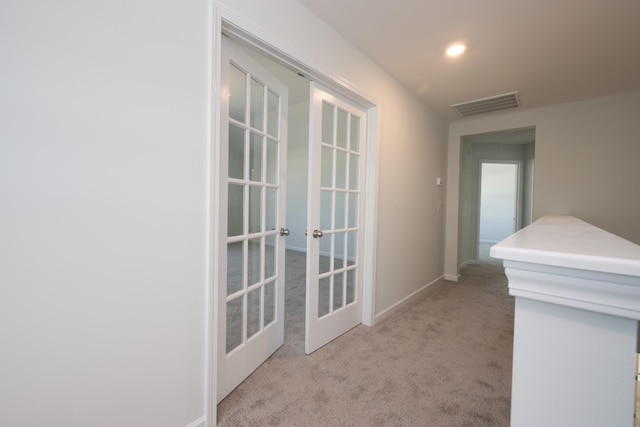 hallway featuring french doors and light colored carpet