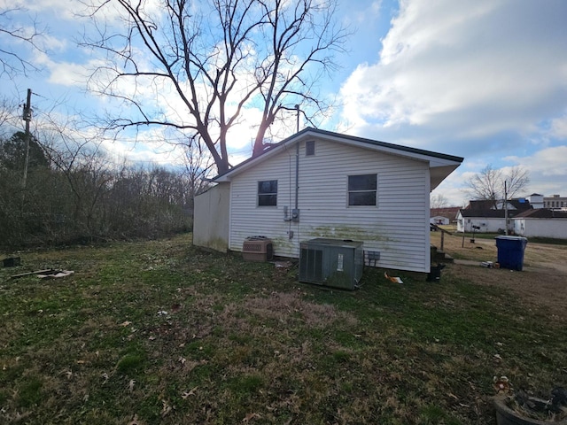 view of property exterior featuring cooling unit and a lawn