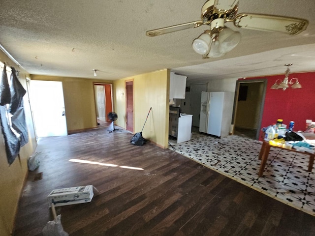 unfurnished living room with ceiling fan with notable chandelier, dark hardwood / wood-style flooring, and a textured ceiling