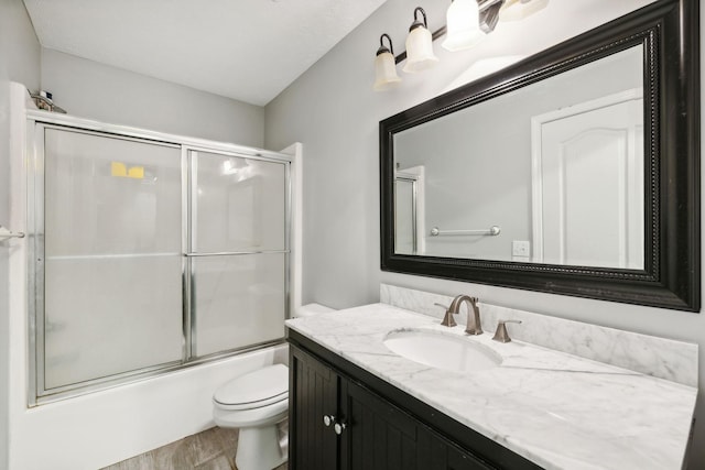 full bathroom featuring vanity, toilet, and bath / shower combo with glass door