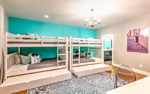 bedroom with hardwood / wood-style floors and a chandelier