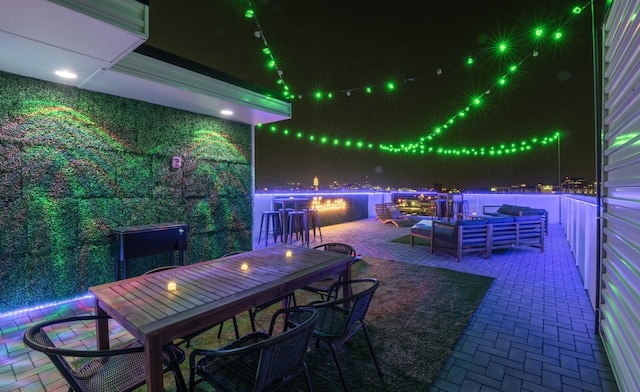 patio at twilight with exterior bar and an outdoor hangout area