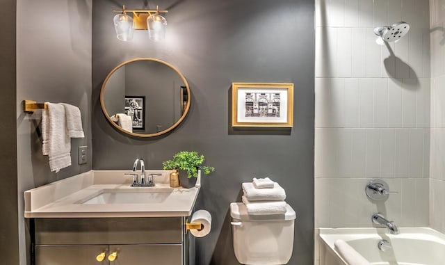 full bathroom featuring vanity, tiled shower / bath combo, and toilet