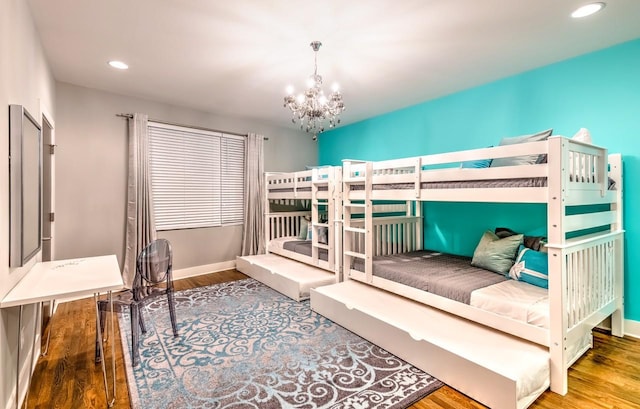 bedroom featuring wood-type flooring and an inviting chandelier