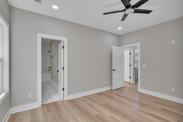 unfurnished bedroom featuring ensuite bathroom, ceiling fan, and light wood-type flooring