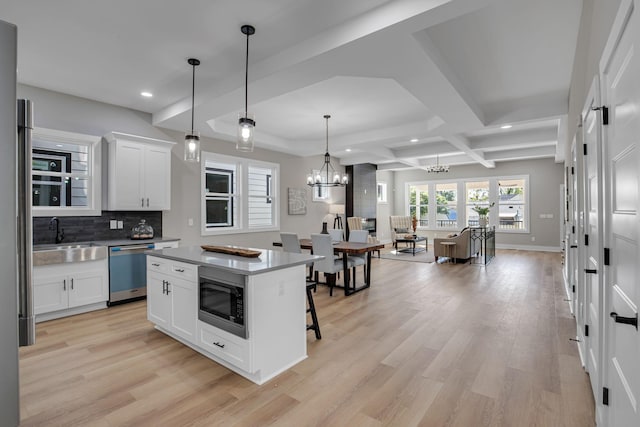 kitchen with dishwasher, a center island, white cabinetry, and built in microwave