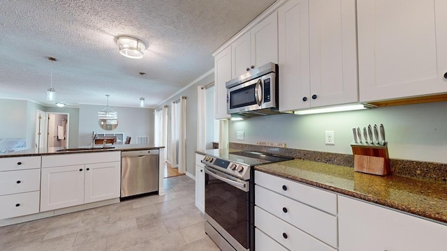 kitchen with dark stone counters, white cabinetry, sink, and stainless steel appliances