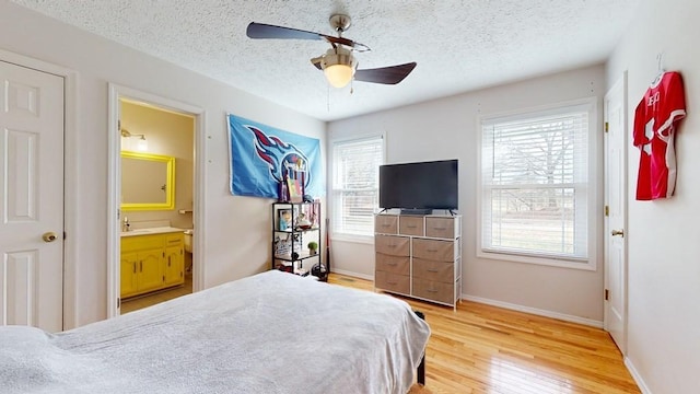 bedroom with ensuite bath, ceiling fan, a textured ceiling, and hardwood / wood-style flooring