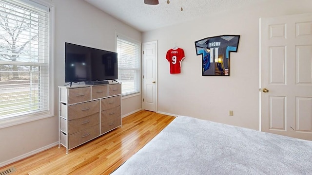 bedroom with wood-type flooring, a textured ceiling, and ceiling fan