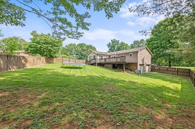 view of yard featuring a deck and a trampoline