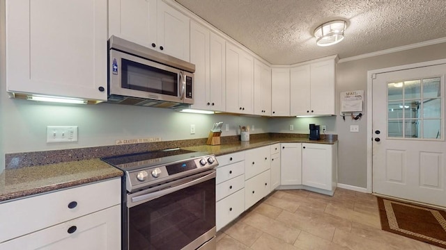 kitchen with white cabinetry, dark stone counters, a textured ceiling, appliances with stainless steel finishes, and ornamental molding