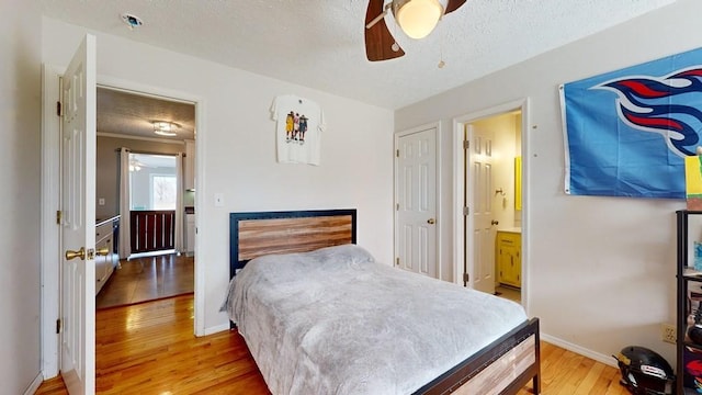 bedroom featuring ceiling fan, hardwood / wood-style floors, ensuite bathroom, and a textured ceiling