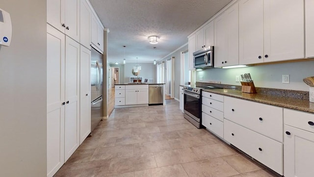 kitchen featuring appliances with stainless steel finishes, a textured ceiling, and white cabinetry