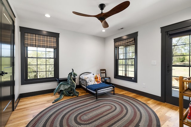 living area with a wealth of natural light, light wood-type flooring, and ceiling fan