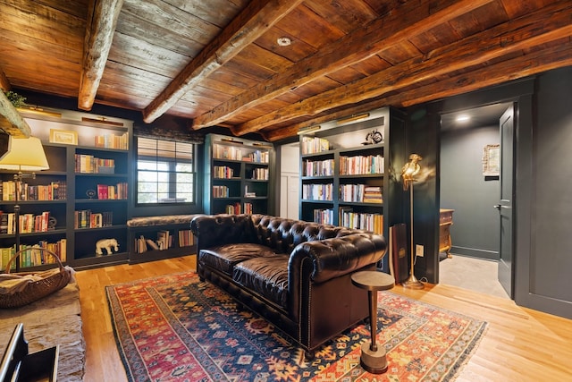 sitting room featuring beam ceiling, light wood-type flooring, and wooden ceiling