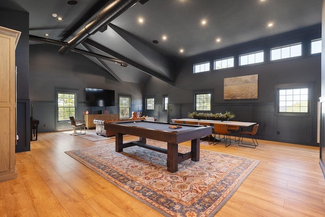 game room featuring a towering ceiling, light hardwood / wood-style floors, and pool table