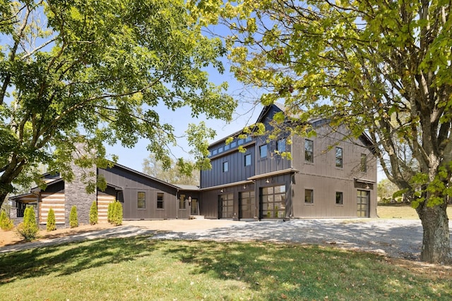 back of property with a yard and a garage